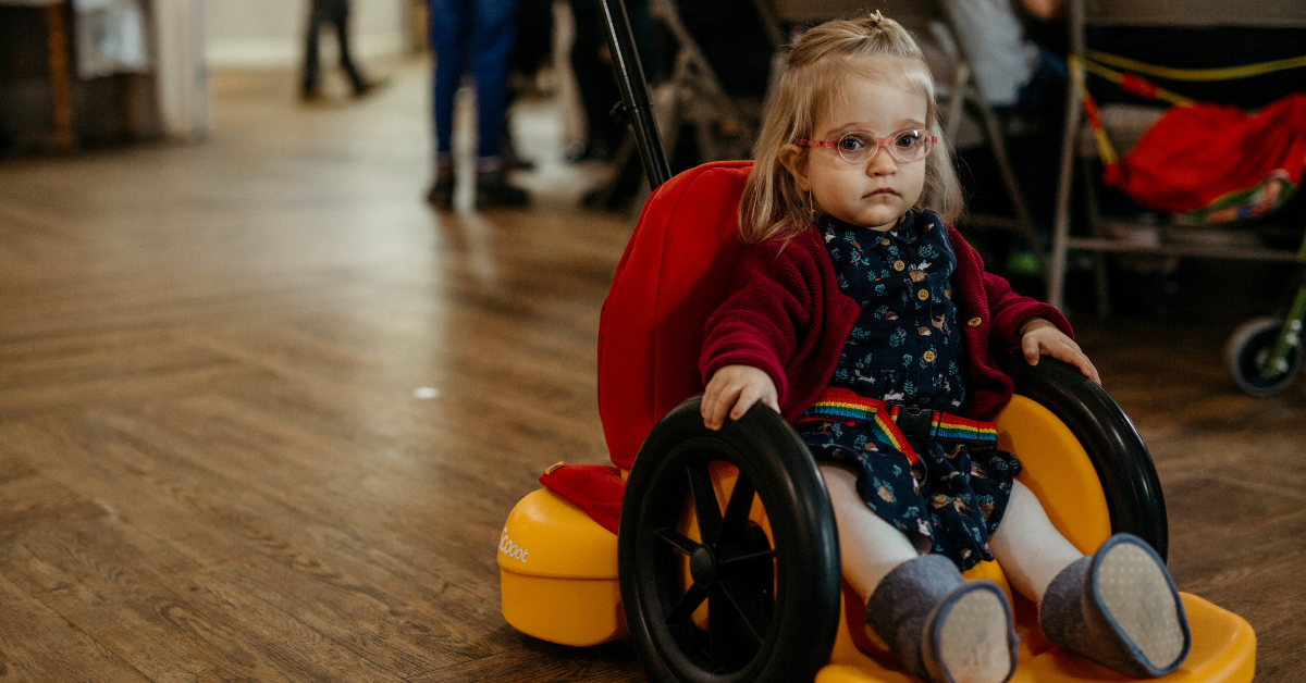 A young girl, who is using a wheelchair, plays at an inclusive playgroup.