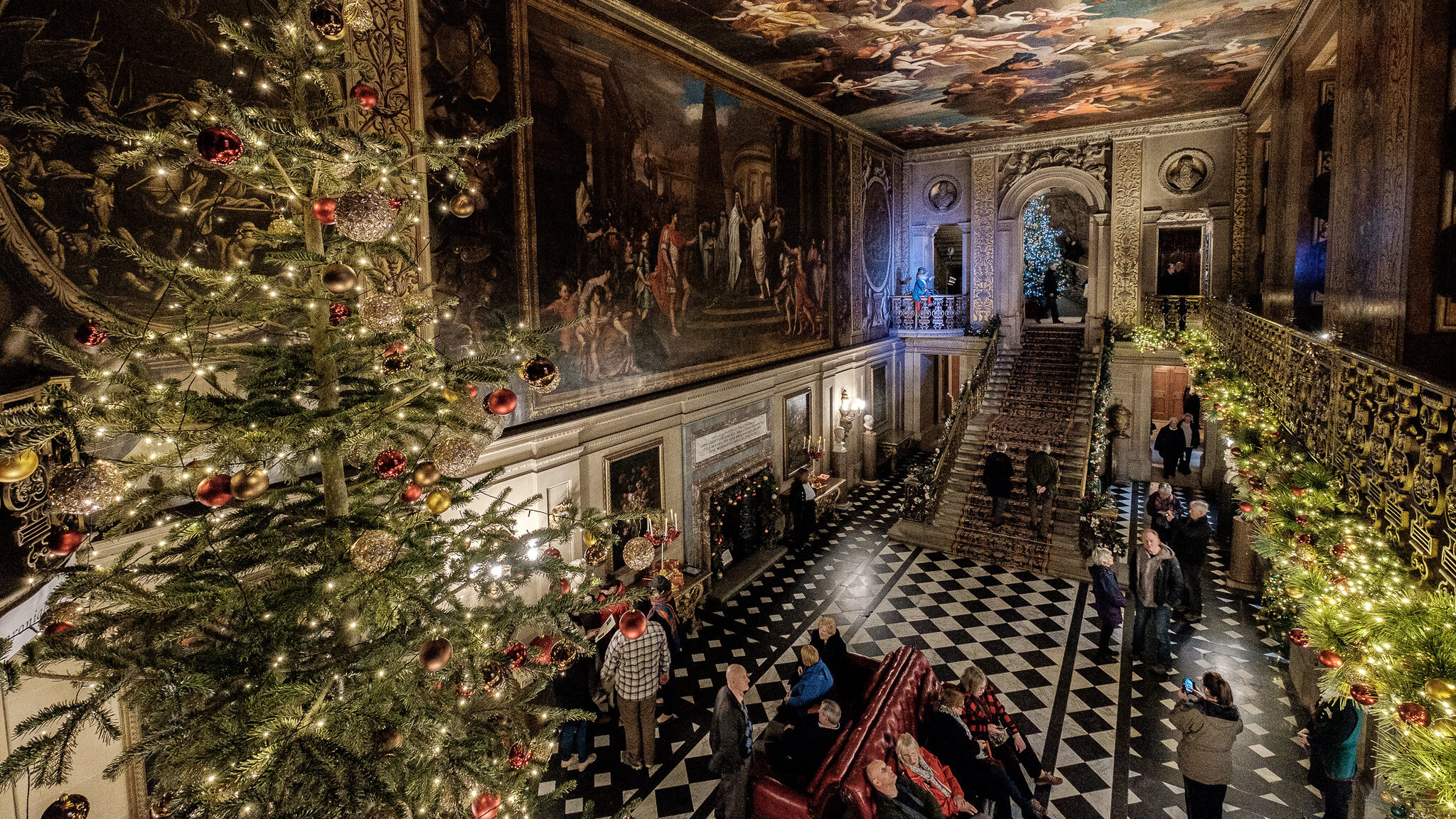 A room in Chatsworth House which is decorated for Christmas with a tree and garlands.